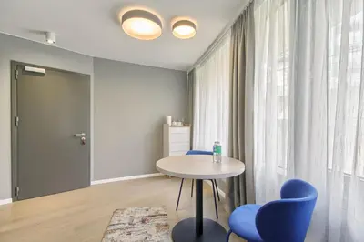 a room with a table and chairs and a window at Asian Magnolia Express Studio Apartments in Druskininkai