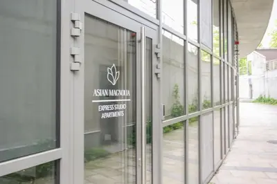 a building with a sign on the side of it at Asian Magnolia Express Studio Apartments in Druskininkai