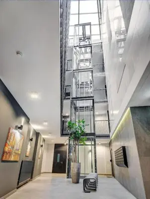 a lobby with a plant in the middle of a building at HaPPy Inn Exclusive studio, Self check in, Parking in Vilnius