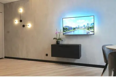 a living room with a tv on a wall at HaPPy Inn Exclusive studio, Self check in, Parking in Vilnius