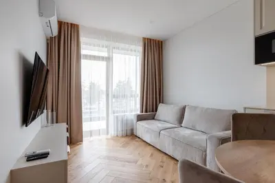 a living room with a couch and a table at Stylish Simplicity - 1BDR Cozy Stay in Vilnius in Kontverki