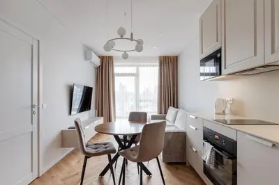 a kitchen and dining room with a table and chairs at Stylish Simplicity - 1BDR Cozy Stay in Vilnius in Kontverki