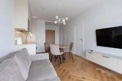 a living room with a couch and a table with chairs at Stylish Simplicity - 1BDR Cozy Stay in Vilnius in Kontverki
