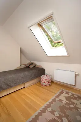 a attic bedroom with a bed and a window at Small House in Trakai Oldtown 1-6 sleeping places in Trakai