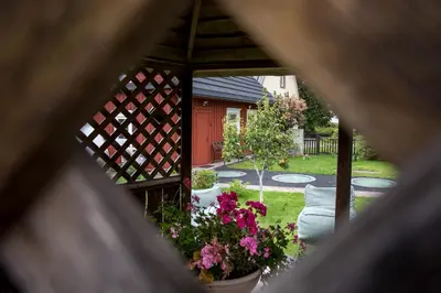 a gazebo with flowers in a yard at Small House in Trakai Oldtown 1-6 sleeping places in Trakai