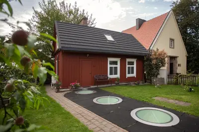 a small red house with a yard with a patio at Small House in Trakai Oldtown 1-6 sleeping places in Trakai