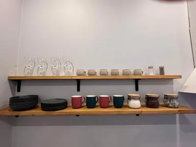 a shelf with bowls and plates and glasses on it at Bastion Apartment Old Town in Vilnius