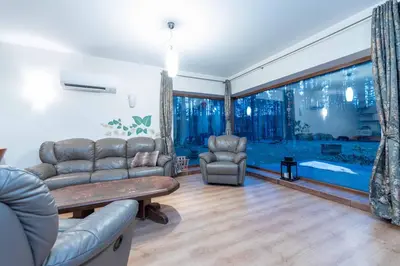 a living room with a couch and chairs and a large window at Margirio namas in Birštonas