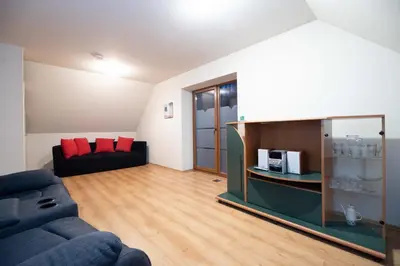 a living room with a blue couch and red pillows at Margirio namas in Birštonas