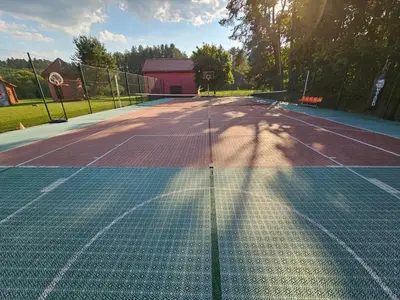 a tennis court with a net on top of it at Vilos NEMUNO SLĖNIS namukai in Birštonas