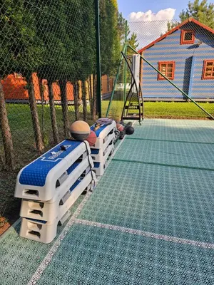 a tennis court with four ping pong tables on it at Vilos NEMUNO SLĖNIS namukai in Birštonas