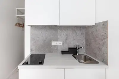 a kitchen with white cabinets and a sink at The K1A Studio Collective in Vilnius