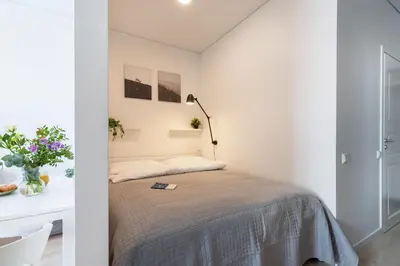 a bedroom with a bed and a desk and a lamp at The K1A Studio Collective in Vilnius