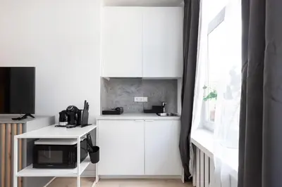 a white kitchen with a microwave and a table at The K1A Studio Collective in Vilnius