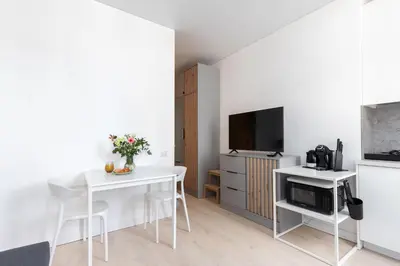 a living room with a table and a tv at The K1A Studio Collective in Vilnius