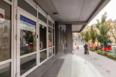 a person walking down a sidewalk in front of a building at The K1A Studio Collective in Vilnius