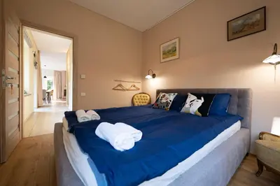 a bedroom with a blue bed with towels on it at Vila Pušyno 4 in Kulautuva