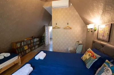 a bedroom with a blue bed and a book shelf at Vila Pušyno 4 in Kulautuva