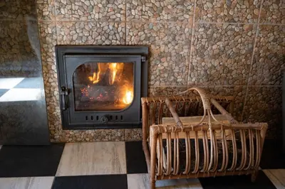 a fireplace in a room with a stone wall at Vila Pušyno 4 in Kulautuva
