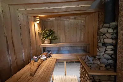 a sauna with a bench and a stone wall at Vila Pušyno 4 in Kulautuva