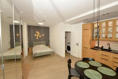a living room with a table and a bedroom at Vilnius Old Town in Vilnius