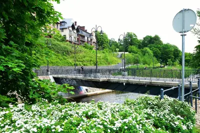 a bridge over a river with white flowers at Vilnius Old Town in Vilnius