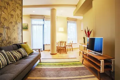 a living room with a couch and a flat screen tv at Ballare House in Druskininkai
