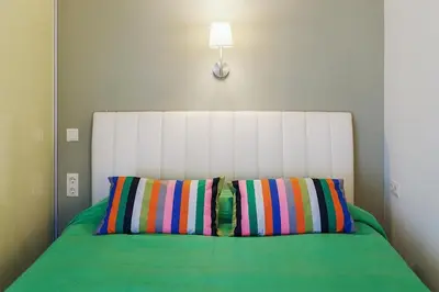 a bed with two colorful pillows in a room at Ballare House in Druskininkai