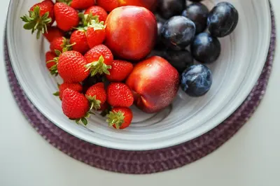 a bowl of strawberries and blueberries on a plate at Ballare House in Druskininkai