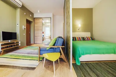a bedroom with a green bed and a television at Ballare House in Druskininkai