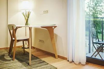 a table and chair in a room with a window at Ballare House in Druskininkai