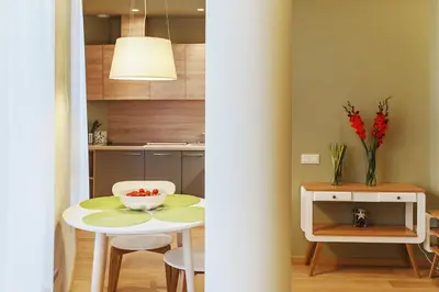 a kitchen and a table with a bowl of fruit on it at Ballare House in Druskininkai