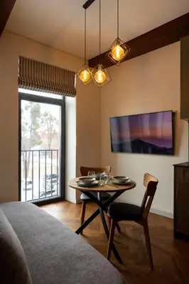 a living room with a table and a tv at Studio Nemuno 27 in Kaunas