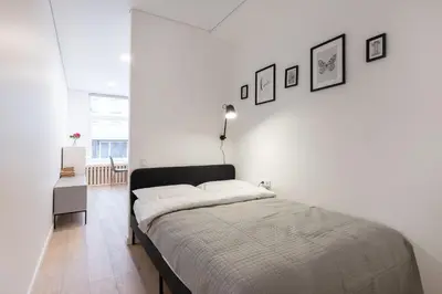 a bedroom with a bed and a white wall at Hook Studios Vilnius Old Town in Vilnius