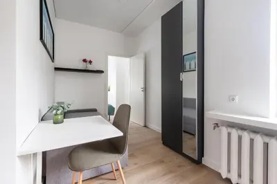 a white dining room with a white table and chairs at Hook Studios Vilnius Old Town in Vilnius