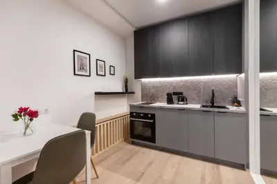 a kitchen with black and white cabinets and a table at Hook Studios Vilnius Old Town in Vilnius