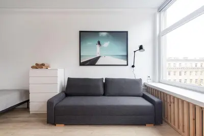 a living room with a couch in front of a lighthouse at Hook Studios Vilnius Old Town in Vilnius