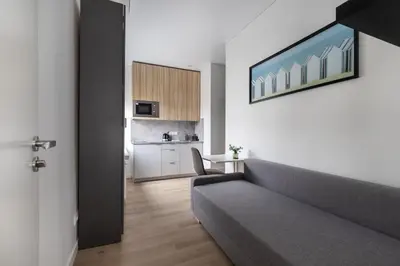 a living room with a couch and a kitchen at Hook Studios Vilnius Old Town in Vilnius