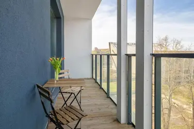 a balcony with a table and two chairs on it at Apartment with balcony and castle view by URBAN RENT in Vilnius