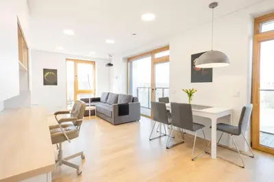 a living room with a table and chairs at Apartment with balcony and castle view by URBAN RENT in Vilnius