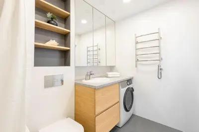 a bathroom with a sink and a washing machine at Apartment with balcony and castle view by URBAN RENT in Vilnius