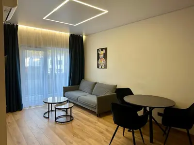 a living room with a couch and two tables at Jaukus butas 2 kambariu girioje in Kaunas