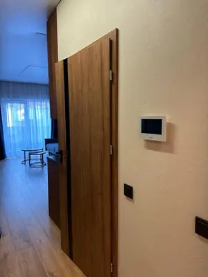 a door to a room with a television on a wall at Jaukus butas 2 kambariu girioje in Kaunas