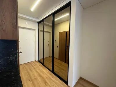 a hallway with a mirror and a door at Jaukus butas 2 kambariu girioje in Kaunas
