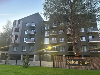 an apartment building with a sign in front of it at Jaukus butas 2 kambariu girioje in Kaunas
