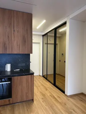 an empty room with a kitchen and a hallway at Jaukus butas 2 kambariu girioje in Kaunas
