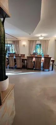 a dining room with chairs and a table and windows at River Mind Villa with SPA in Zalioji