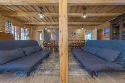 a living room with blue couches in a room with tables at Sporto ir poilsio centras KORNEALITA IEVALAUKIS in Gaveikėnai