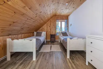 a bedroom with two beds and a wooden ceiling at Sporto ir poilsio centras KORNEALITA IEVALAUKIS in Gaveikėnai