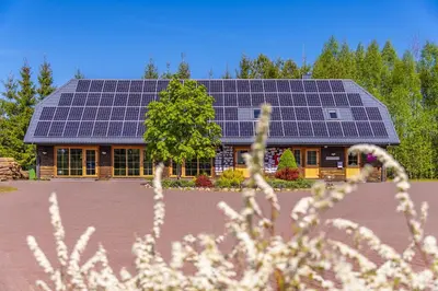 a house with solar panels on top of it at Sporto ir poilsio centras KORNEALITA IEVALAUKIS in Gaveikėnai
